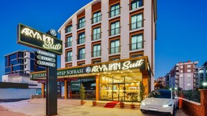A hotel with a modern facade, multiple floors, and a prominent entrance. - ARYA INN SUİT  (Serik)