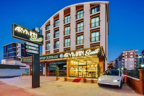 Un hotel con fachada moderna, varios pisos y una entrada destacada.