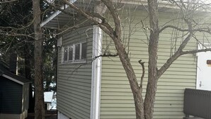 A house with a small porch and a tree in front. - Cozy 1BR hotel room, Hamilton - #348 Iroquois (Hamilton)