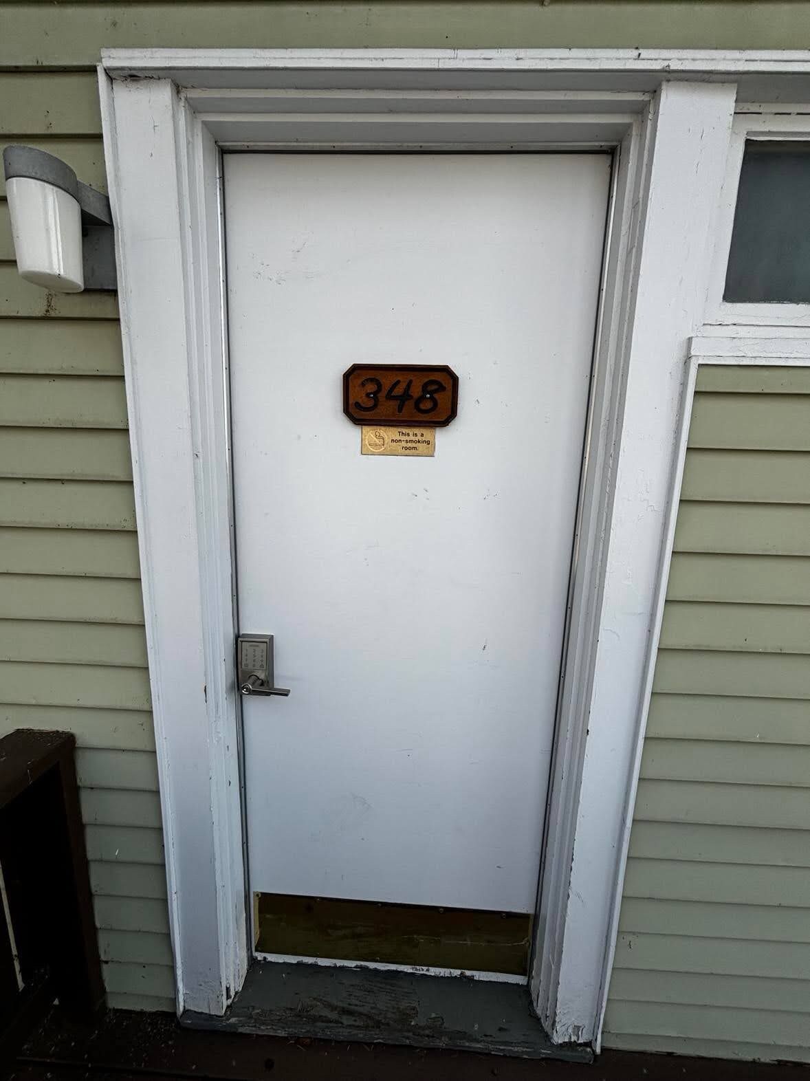 A white door with a number plate indicating '348' and a sign stating 'This is a non-smoking room.'