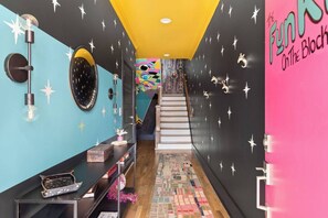Ein Flur mit Treppe, Stern-Dekorationen und einem farbenfrohen Wandgemälde.