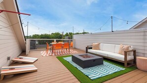 Una terrassa al terrat amb una xemeneia, seients exteriors i una vista del cel.