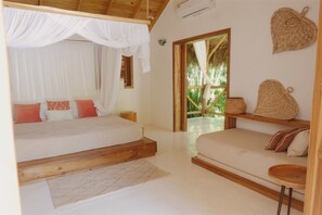 A bedroom with a canopy bed, a sofa, a small table, and a view of the outdoors. - 2-bedroom apartment in soothing Punta Cana with AC and gym access (Punta Cana)