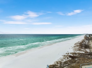 Une plage offrant une vue dégagée sur l’océan et bordée d’un rivage sablonneux.