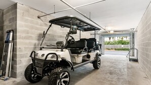 A golf cart parked in a garage with concrete walls and a metal roof. - 202C - Drift Aweigh *Golf Cart Included* (Miramar Beach)