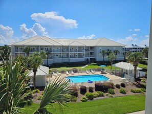 Ein Hotel mit Schwimmbad, mehreren Balkonen und Palmen.