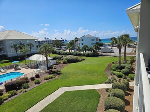 Ein Resort mit Swimmingpool, gepflegter Rasenfläche und Gebäuden mit Balkonen mit Blick auf den Ozean.