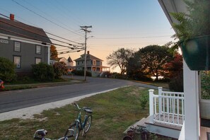 A residential street with houses, a bicycle, and a white fence. - Lock`s Nest on Peaks Island Maine (Portland)