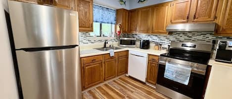 A kitchen with wooden cabinets, stainless steel appliances, and a tiled backsplash.