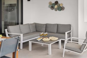 Ein modernes Wohnzimmer mit einer grauen Eckcouch, einem weißen Couchtisch und passenden Sessel.