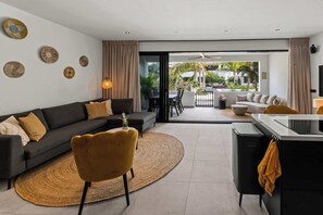 A modern living room with a sofa, armchairs, a coffee table, and a dining area with chairs and a table. - Azure stay - Luxury Stay - Pool - Santa Rosa (Mahaai)