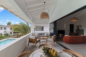 Ein moderner Außenbereich mit Pool, Esstisch mit Obst und Blick auf ein Wohngebäude.