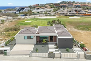 A modern two-story house with a flat roof, a driveway, and a well-maintained lawn. - Villa Azure Fairways- luxury villa at Bluebay (Bluebay)