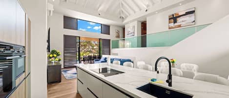 A modern kitchen with a central island, built-in appliances, and a view to the outdoors.