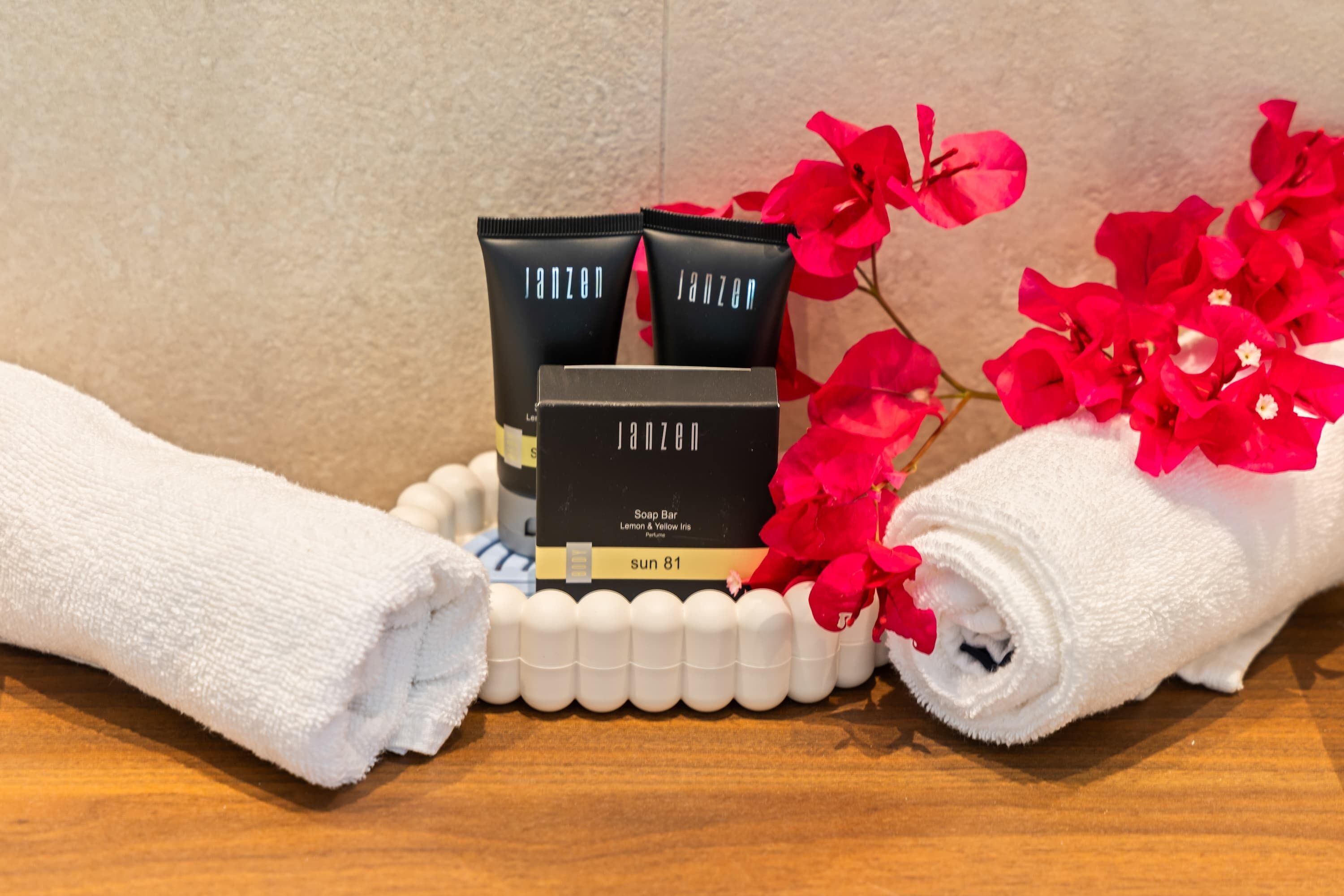 A bathroom setting with toiletries, towels, and decorative flowers.