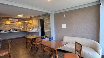 A modern living room with a wooden dining table, chairs, and a sofa.