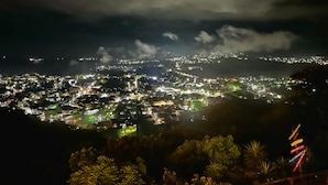 Ein beleuchtetes Stadtbild bei Nacht mit Wolkenhimmel.