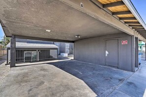 Einfahrt einer Parkgarage mit einem 'NO TRESPASSING'-Schild, einem Betonboden und einem Metallgitter.