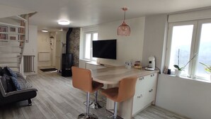 Una cocina moderna con una televisión de pantalla plana, una cafetera y un amplio ventanal.