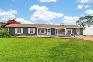 A single-story house with a front porch, a small lawn, and a clear sky.