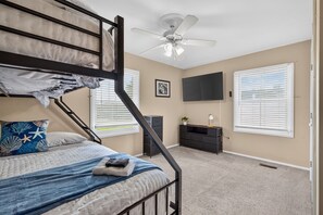 A bedroom with bunk beds, a ceiling fan, a TV, and a desk with drawers. - Best of Grandview! 7 Beds, waterfront & dock! (Hampton)