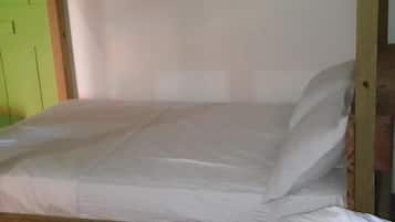 A single bed with a wooden frame and white bedding.