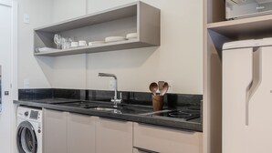 Una cocina moderna con lavadora integrada, un lavamanos y una repisa sobre la encimera.