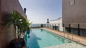 A rooftop pool with a clear view of the city skyline, surrounded by modern buildings and a potted plant. - Studio w/ Pool & BBQ 300m From Sea Vfr505 (Bombinhas)