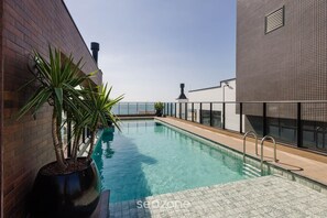 A rooftop pool with a clear view of the city skyline, surrounded by modern buildings and a potted plant. - Studio w/ Pool & BBQ 300m From Sea Vfr505 (Bombinhas)