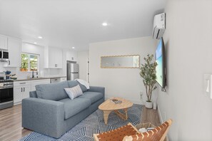 A modern kitchen with white cabinets, a built-in oven, and a microwave. - Charming Ocean Beach Cottage: A/C + Yard + Free Parking (San Diego)