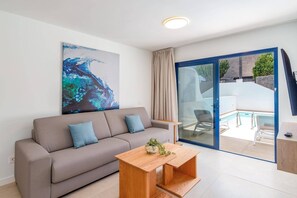 A modern living room with a sofa, a coffee table, and a large abstract painting. - Villa Marejada by Villa Plus (Playa Blanca)