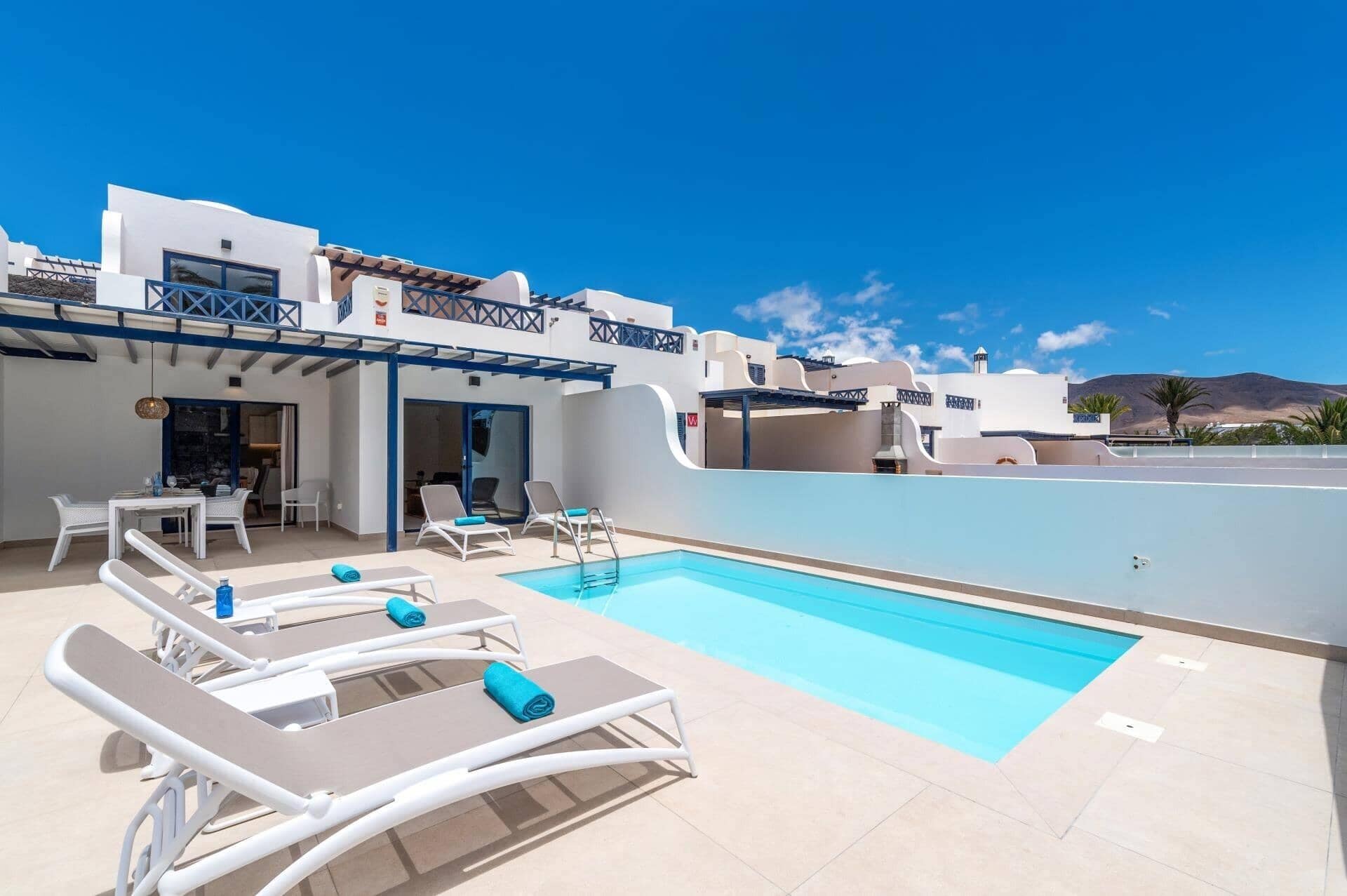 A poolside area with lounge chairs and a pool.