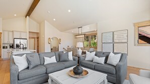 A spacious living room with a grey sectional sofa, a white coffee table, and a kitchen area in the background. - Perfect Family Getaway: 4BR with Stunning Alpine Views (Keystone)