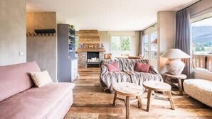 Ein geräumiger Wohnbereich mit einer Couch, einem Couchtisch und einem Kamin.