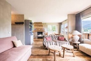 Ein geräumiger Wohnbereich mit einer Couch, einem Couchtisch und einem Kamin.