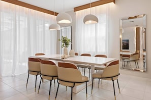 A modern dining room with a rectangular table, six chairs, and pendant lighting. - 9024 Solara brand new theme rooms pool near club (Kissimmee)