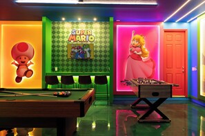 A brightly lit room with a pool table, a foosball table, and a Super Mario-themed wall. - 9024 Solara brand new theme rooms pool near club (Kissimmee)