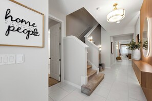 A modern interior with a staircase, a hallway, and a wall with a motivational quote. - 9024 Solara brand new theme rooms pool near club (Kissimmee)