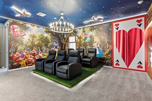 A room with a mural of animated characters, a chandelier, and a large playing card on the wall. - 9024 Solara brand new theme rooms pool near club (Kissimmee)