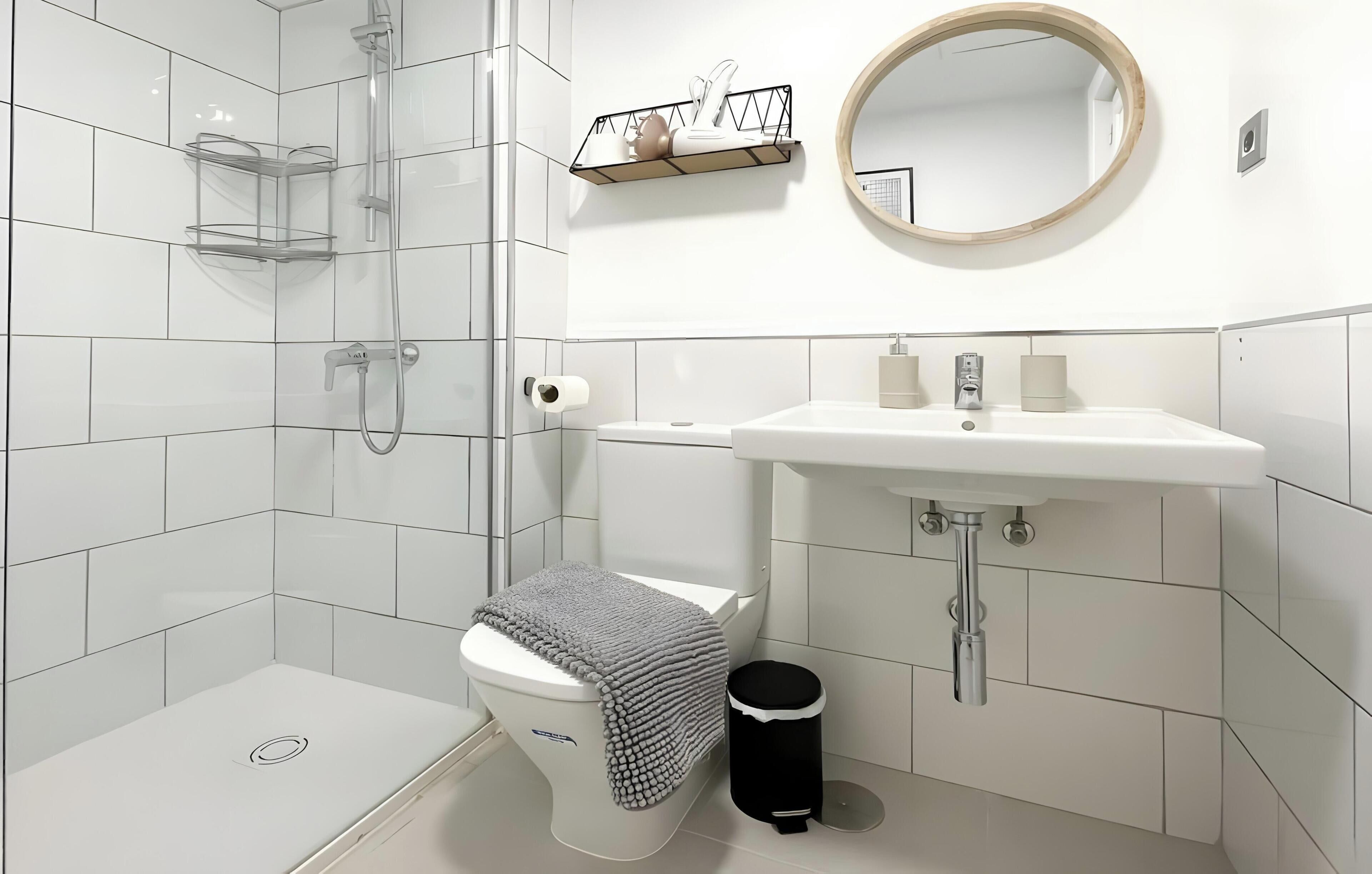 Et moderne badeværelse med toilet, bidet og bruser.