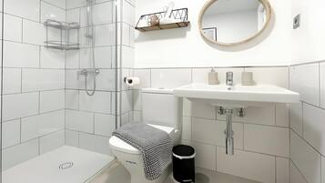 Et moderne badeværelse med toilet, bidet og bruser.