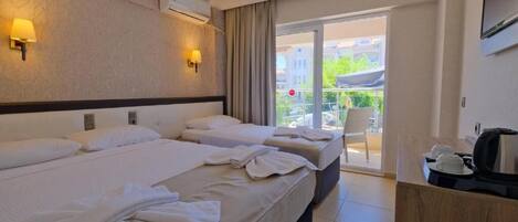A hotel room with two beds, a balcony with a view, and a TV mounted on the wall.
