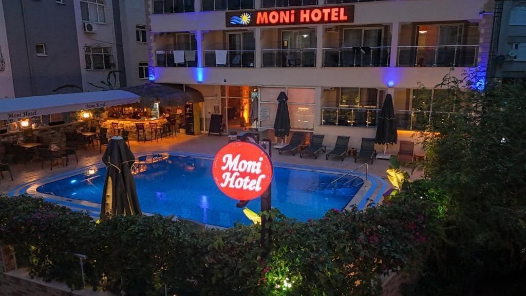 A hotel with a swimming pool, outdoor seating, and a bar area.