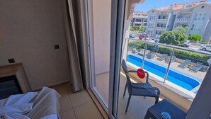 A balcony with a pool, a chair, and a table. - MONİ HOTEL (Marmaris)