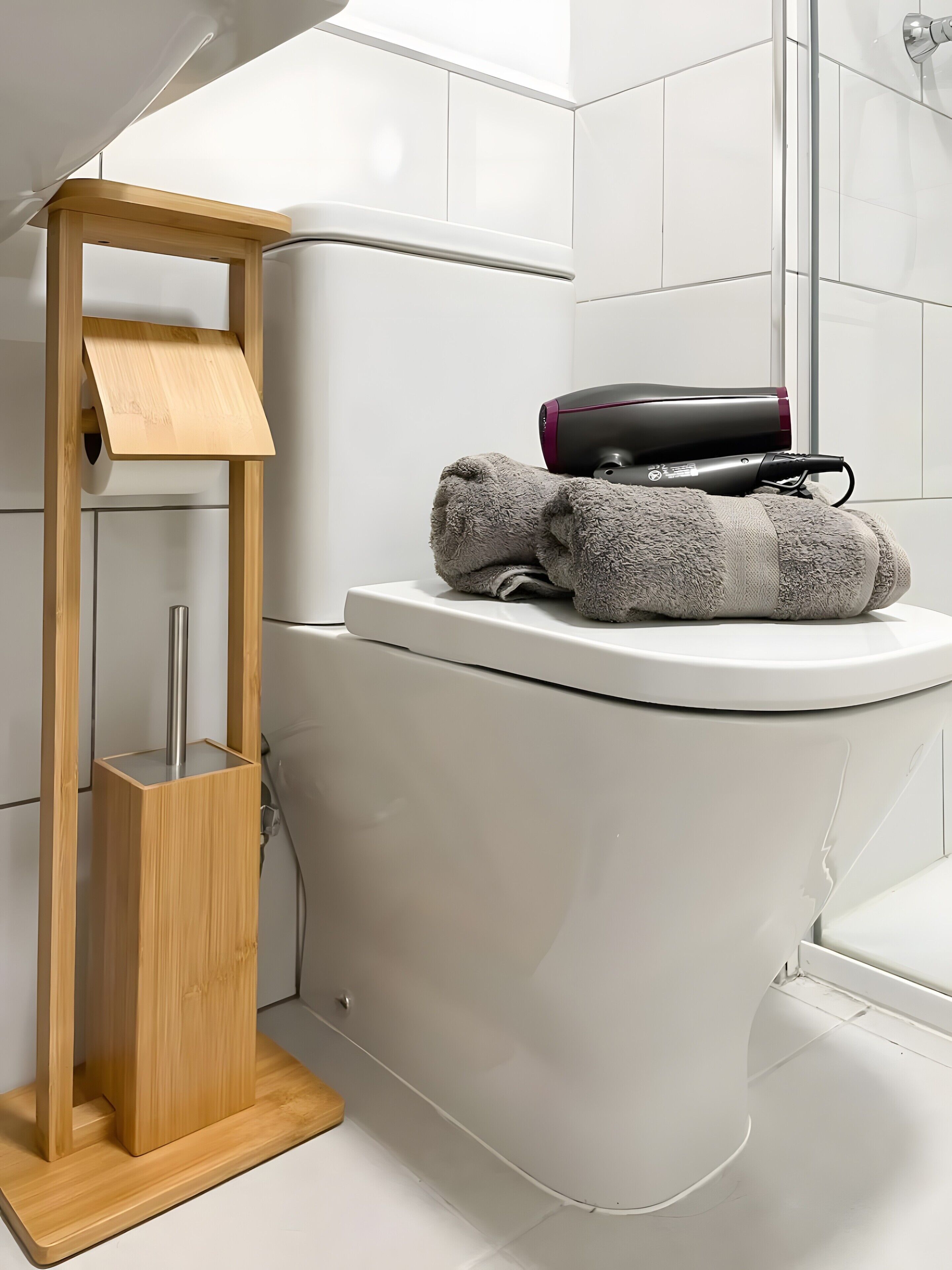 Een moderne badkamer met toilet, een houten plank en een handdoek.