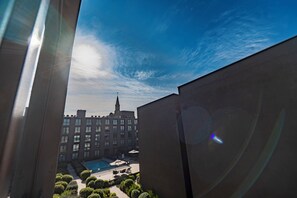 A view of a building with a swimming pool and a church spire in the background. - Executive Office · Gym · Coworking Space · Cumming Metro Station (Santiago)