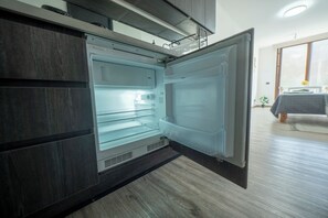 An open refrigerator with a water dispenser, a freezer compartment, and a control panel. - Executive Office · Gym · Coworking Space · Cumming Metro Station (Santiago)