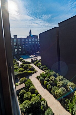A courtyard with a swimming pool, surrounded by neatly trimmed bushes and a pathway. - Executive Office · Gym · Coworking Space · Cumming Metro Station (Santiago)