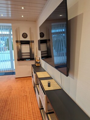Ein modernes Hotelzimmer mit großem Spiegel, einer Minibar und Blick ins Freie.