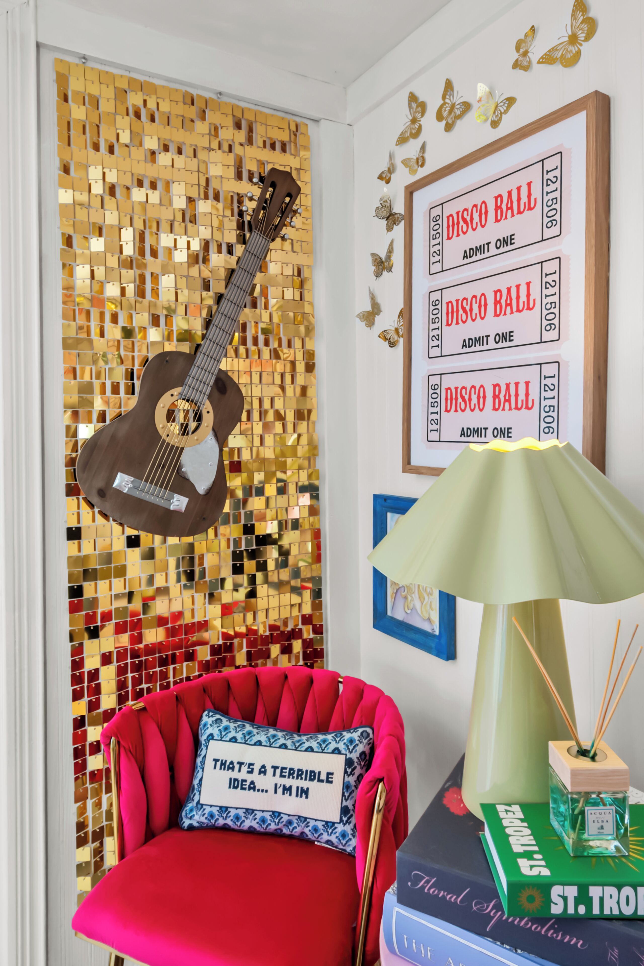 Una habitación con una silla roja, una guitarra y una pared decorada con letreros de bola de discoteca y mariposas.